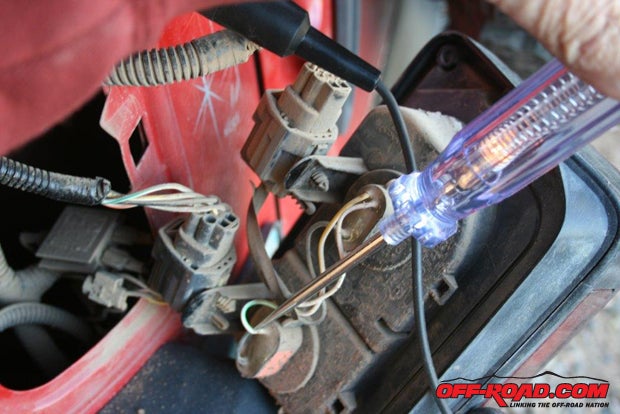 The lower light socket is for the backup light, which on a JK is supplied by a green/white power wire and a black ground wire. I used solderless connectors and then taped them thoroughly since the backs of the taillights are open to tire-thrown debris and moisture.