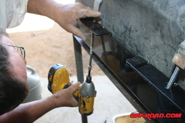 Tighten both straps until the tank cannot move about in the skid plate.