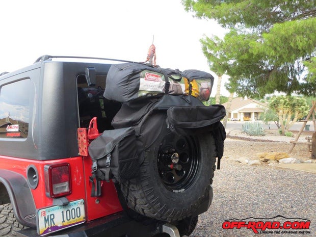 RoughRider Spare Tire Organizers are said to be a first in exterior storage solutions with applications for 30-inch-diameter spare tires up to big-dog 40-inch tires. There are two pocket groups on either side; one large and one medium pocket, and both use an extruded channel attachment system for quick removal and installation. And theres a horizontally mounted quick-access pocket on the front. Securing with a strap system encompassing the diameter of the whole tirein this case a 35-inch Goodyear Dura-Trac tireplus the tire backside, it stays in place on the road or on the trails. A handy strap on top helps secure whatever else you need to keep tied down.