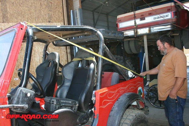 From the top lip of the windshield frame to the rear point of the body above the Jeeps taillight, you want 75-1/8 inches. To achieve this measurement, use the windshields dashboard clamps. Their mounting torx screws are also adjustment screws, so you can loosen them and pull the windshield backward to make the distance shorter or push it forward to make it longer. Once the correct distance is achieved, tighten the screws and double-check the result.