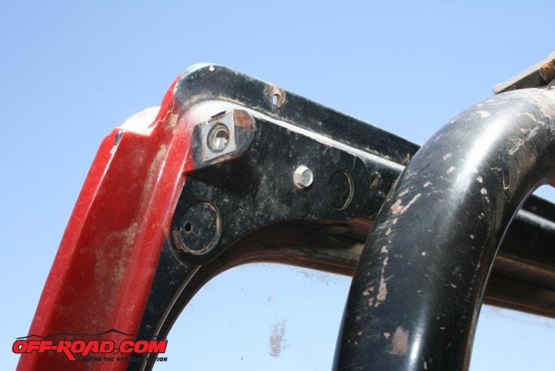 Install the windshield brackets in each upper corner of the windshield frame. If the sun visors are still in place, remove them temporarily and then re-secure them along with the brackets. Use the bracket as a template if you need to drill any holes.