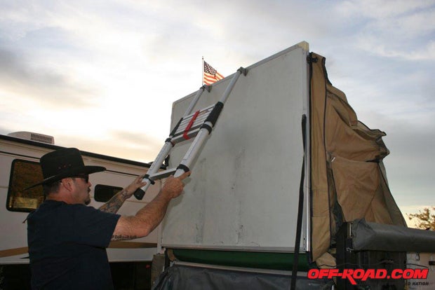 Grab the adjustable ladder and lift the tents floor up and then drop it into position.